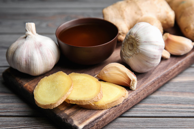 Photo of Fresh garlic and other natural cold remedies on light grey wooden table