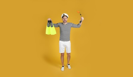 Photo of Excited sailor with swim fins and snorkel on white background
