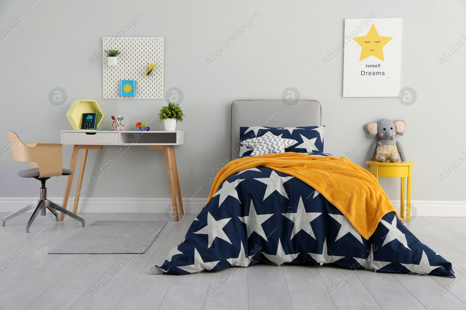 Photo of Bed with star patterned linens in child's bedroom. Interior design
