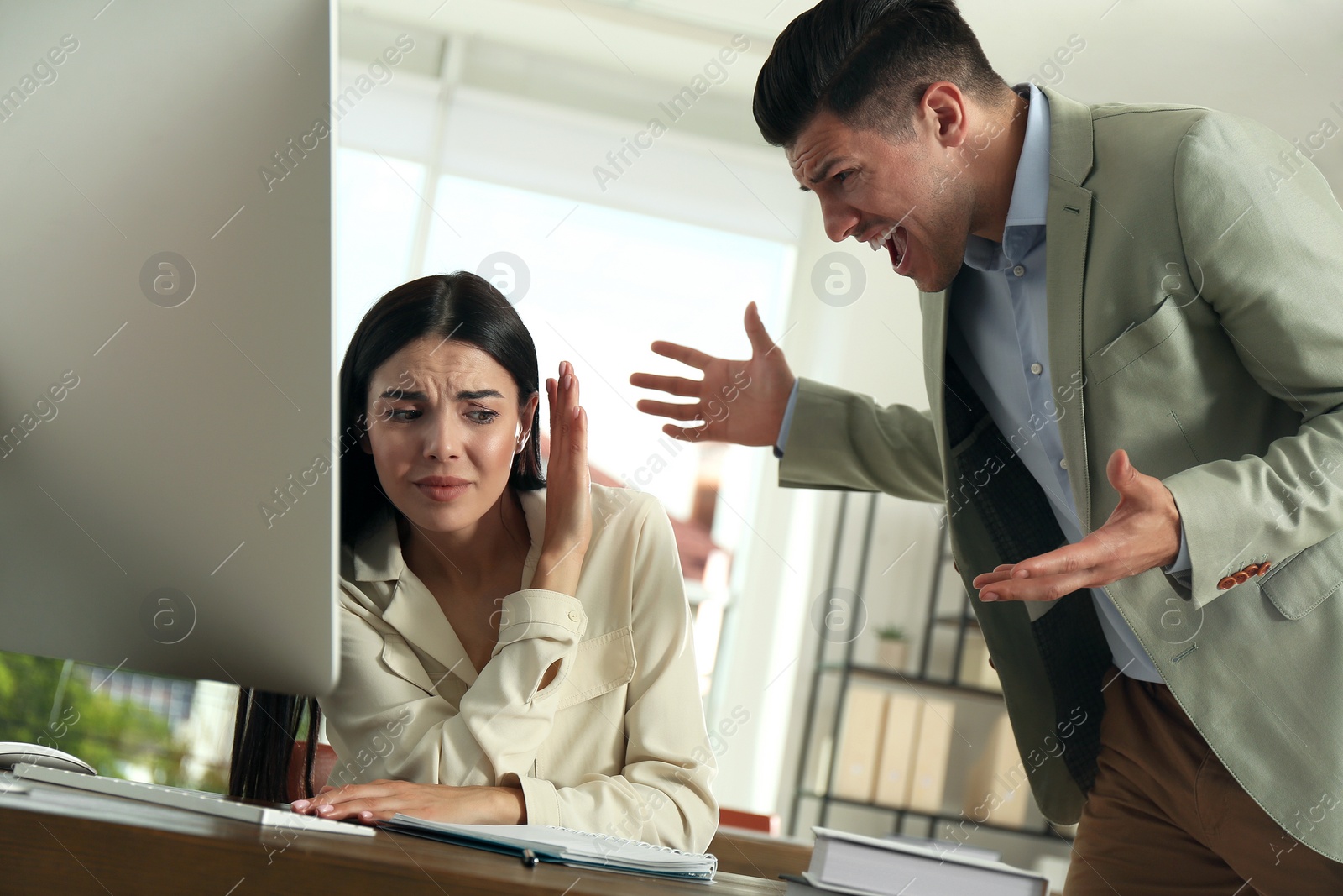 Photo of Boss screaming at employee in office. Toxic work environment