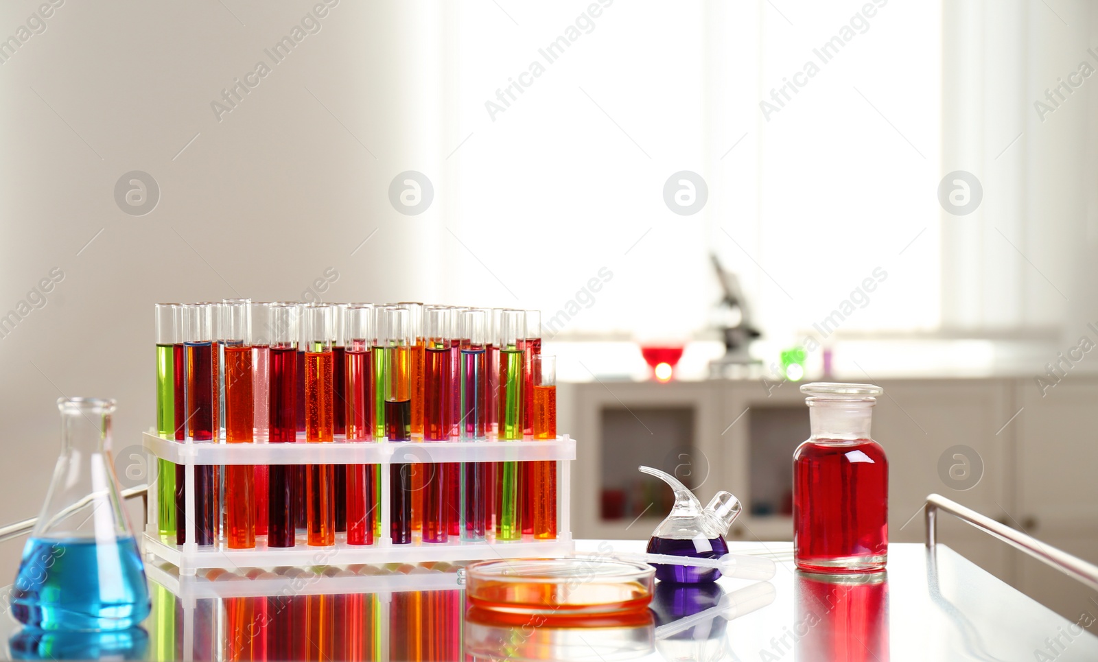 Photo of Laboratory glassware with color liquids on table. Solution chemistry