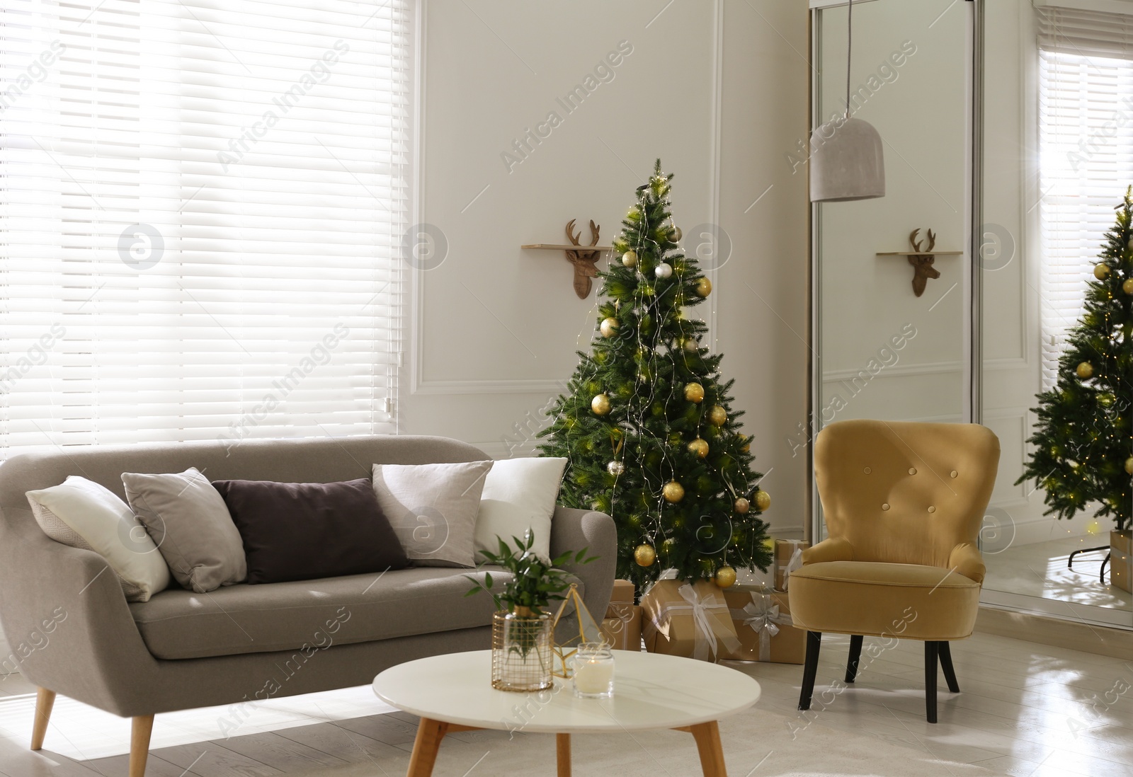 Photo of Beautiful Christmas tree and sofa in contemporary living room. Interior design