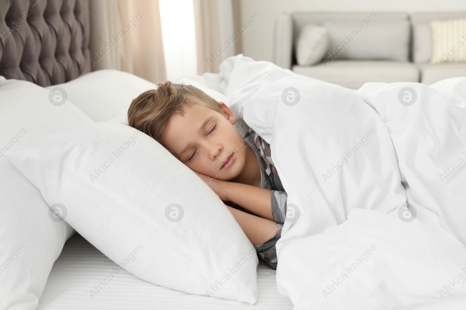 Photo of Cute tired boy sleeping in comfortable bed