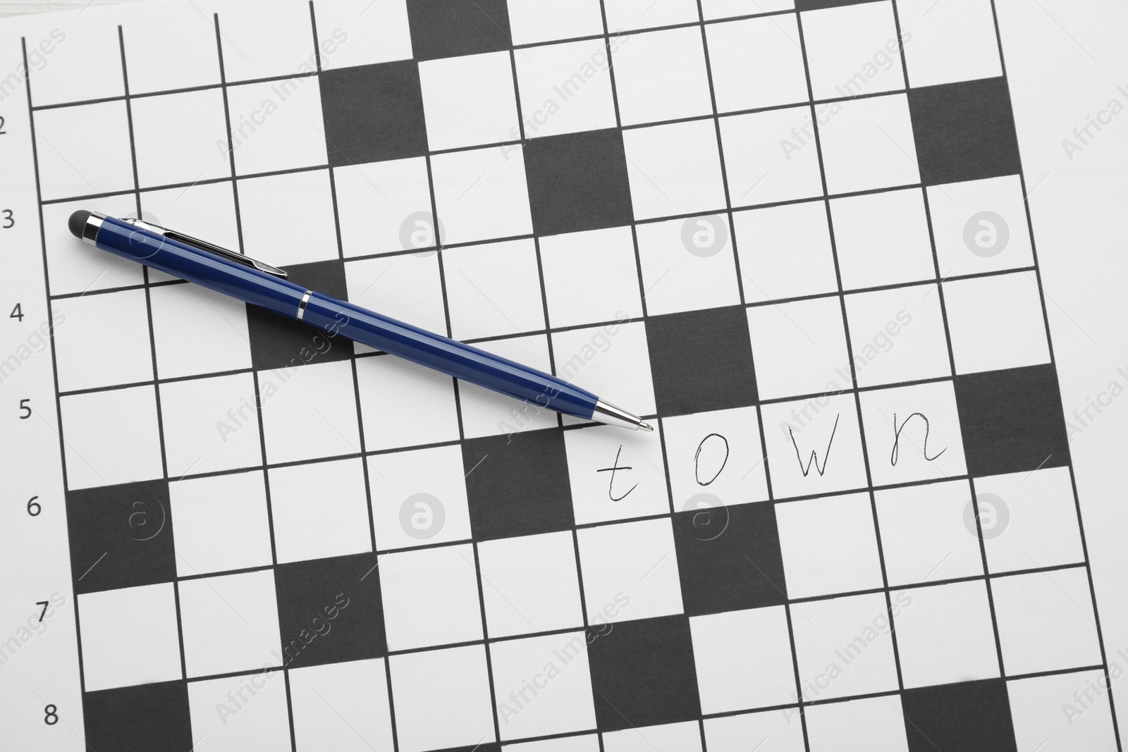 Photo of Crossword with answer and pen, top view