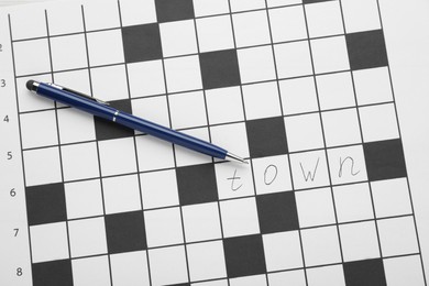 Crossword with answer and pen, top view