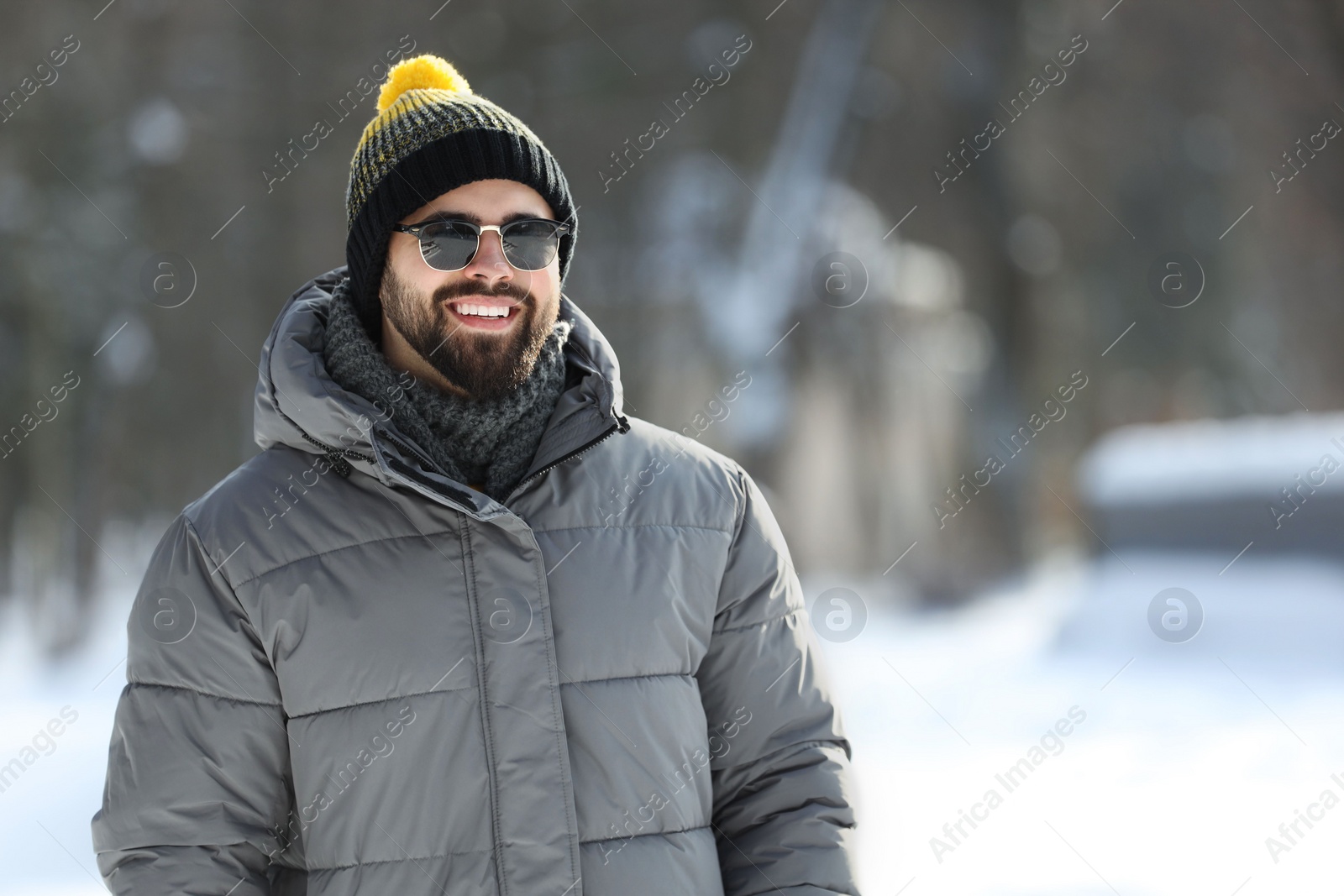 Photo of Portrait of handsome young man with sunglasses on winter day outdoors