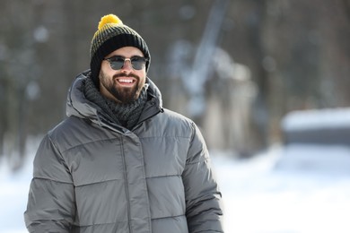 Photo of Portrait of handsome young man with sunglasses on winter day outdoors