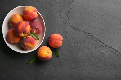 Fresh sweet peaches on black table, flat lay. Space for text