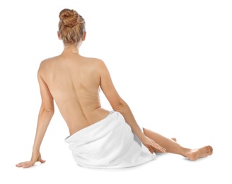 Young woman with soft towel sitting on white background