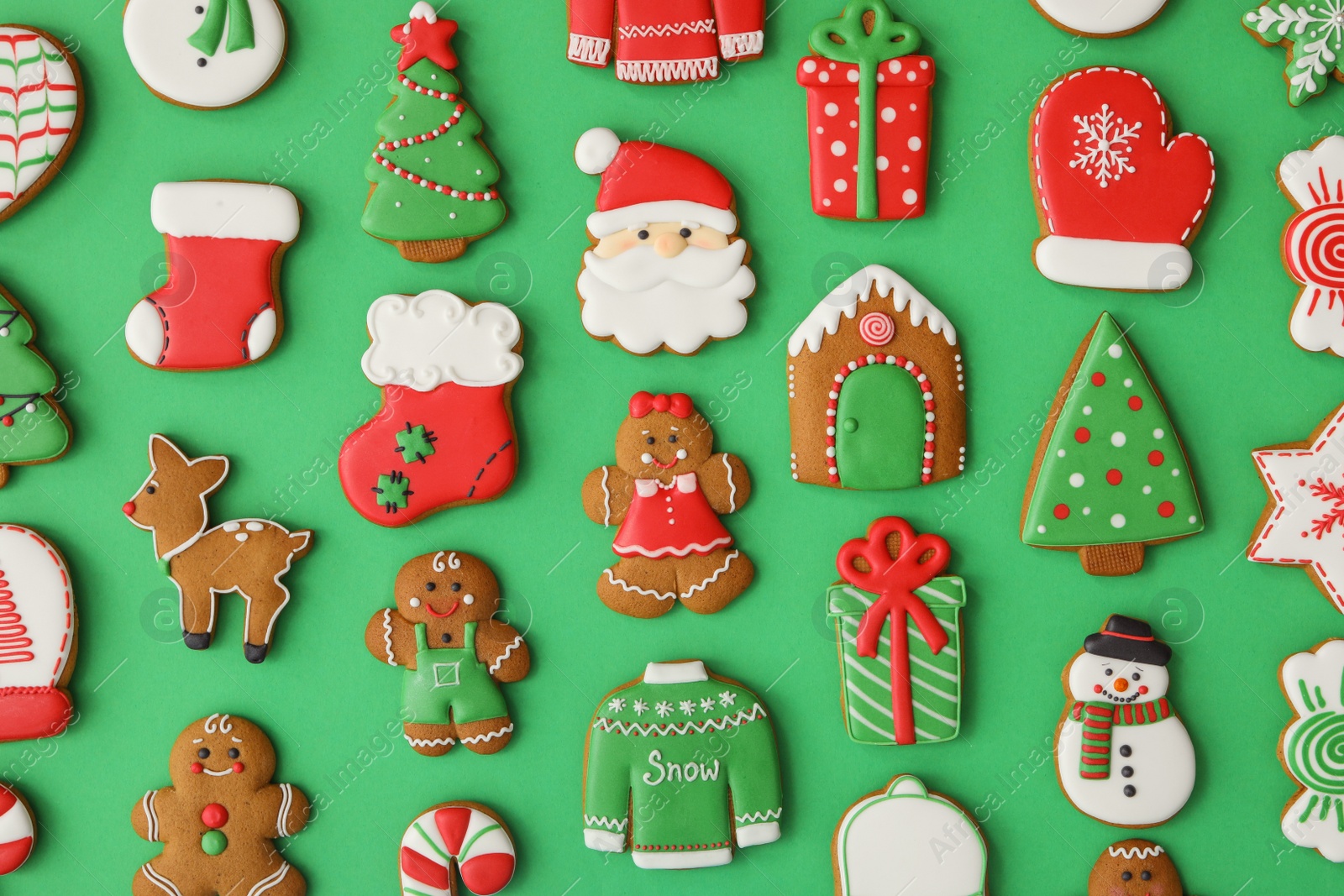 Photo of Different Christmas gingerbread cookies on green background, flat lay