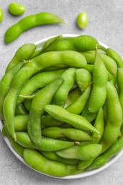 Photo of Green edamame beans in pods on light grey table, flat lay