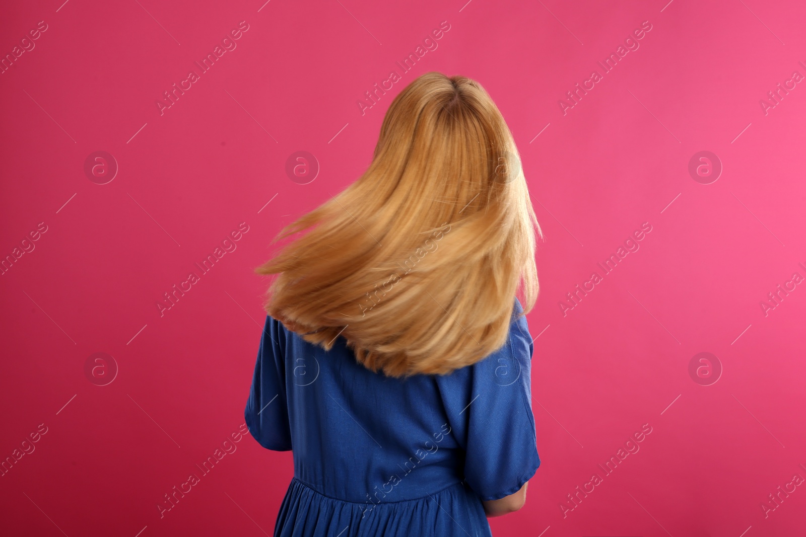 Photo of Beautiful young woman with blonde hair on pink background