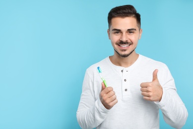 Photo of Young man with toothbrush on color background, space for text. Teeth care