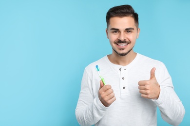 Young man with toothbrush on color background, space for text. Teeth care