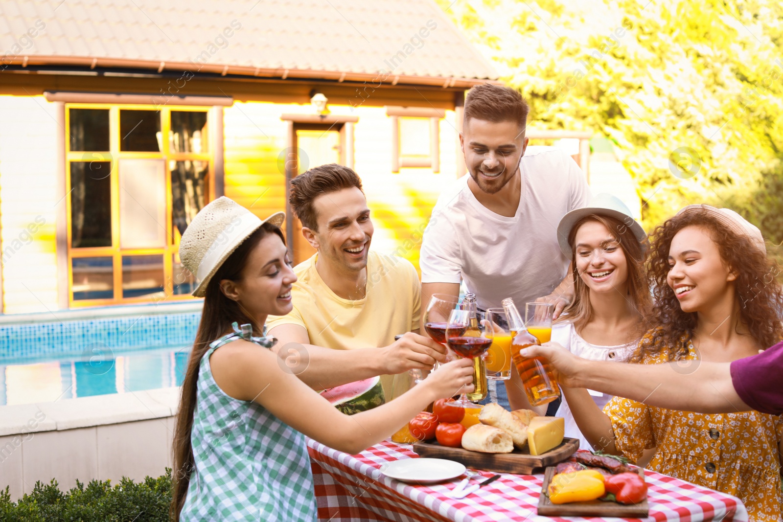 Photo of Happy friends with drinks having fun at barbecue party outdoors