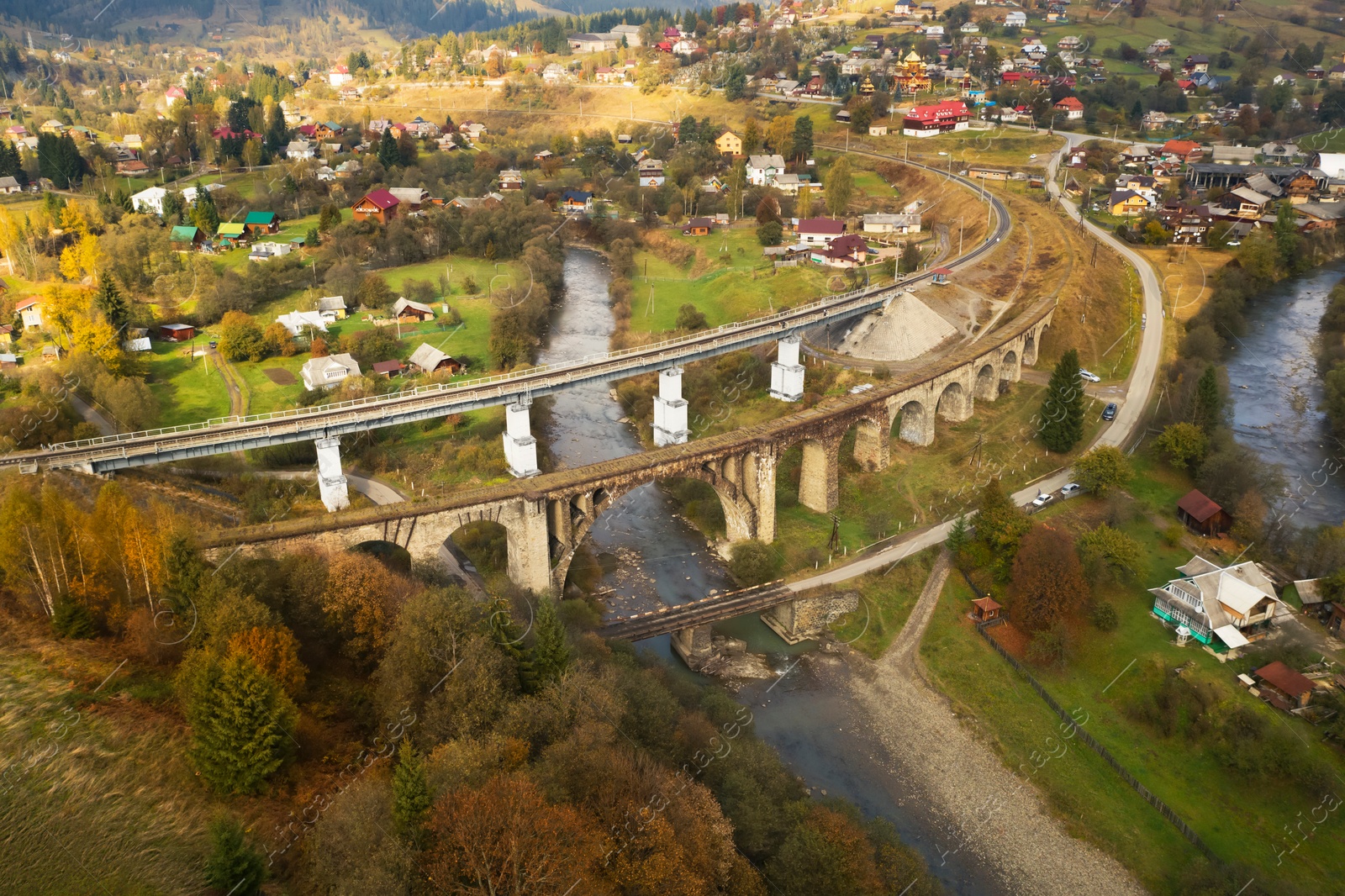 Image of Aerial view of bridges and village on autumn day