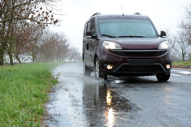 Photo of Wet suburban road with car on rainy day