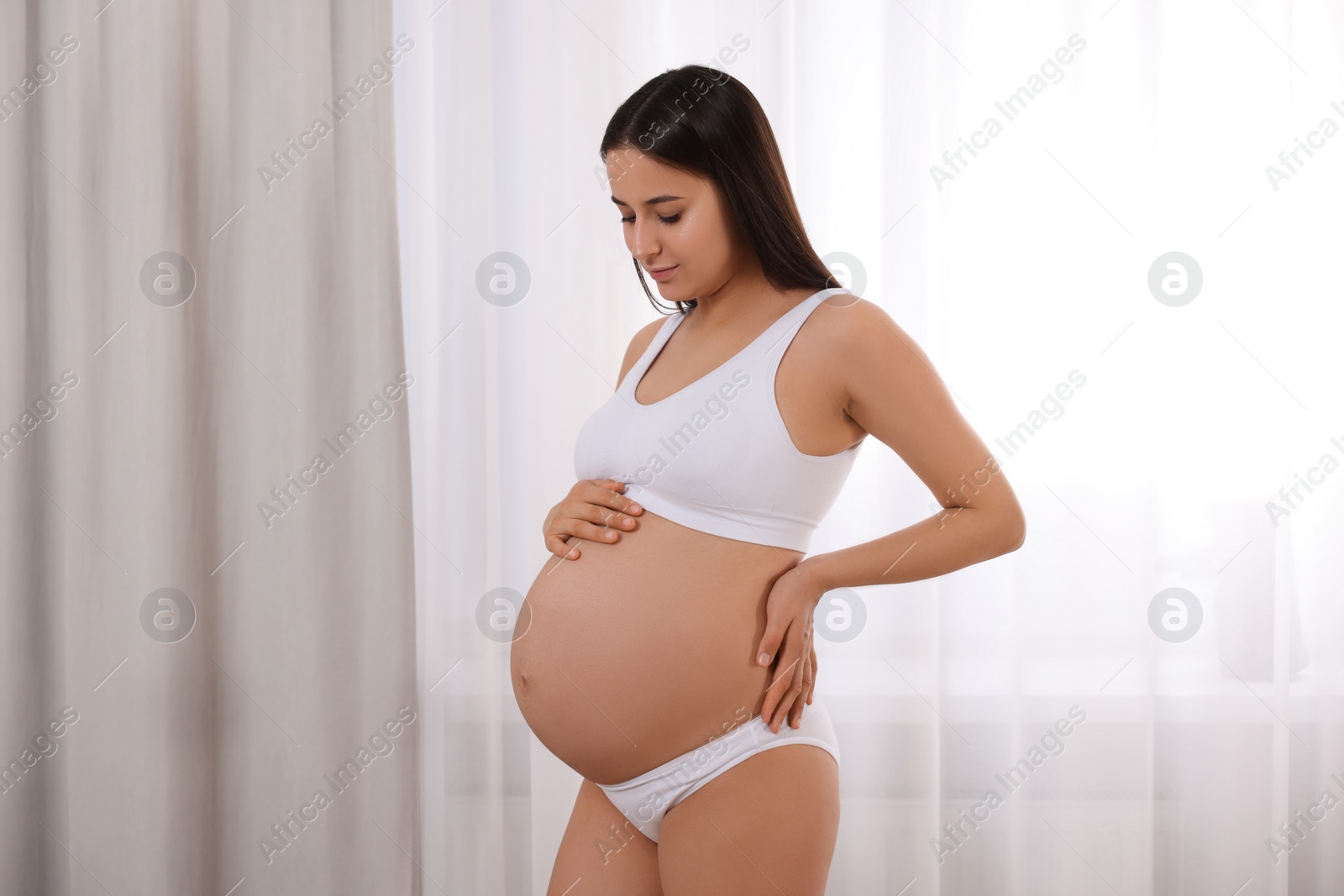 Photo of Beautiful pregnant woman in stylish comfortable underwear indoors