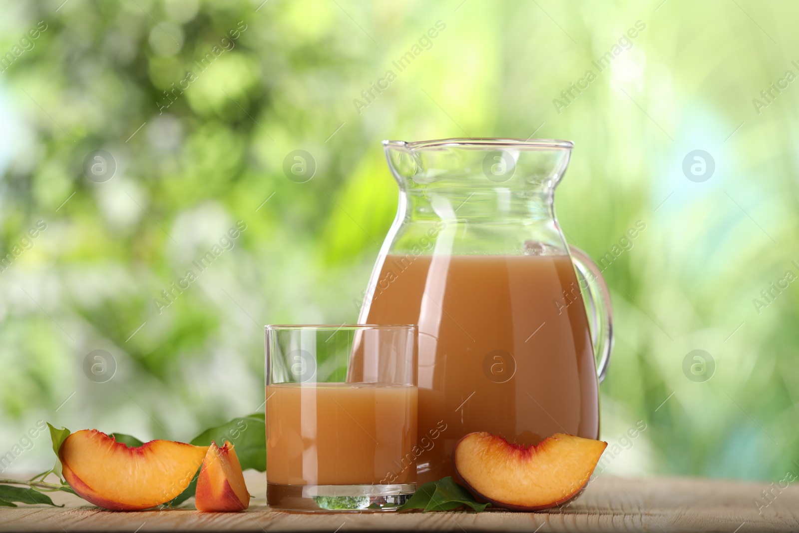 Photo of Tasty peach juice and fresh fruit on wooden table outdoors