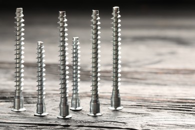 Photo of Countersunk screws on wooden table, closeup. Space for text