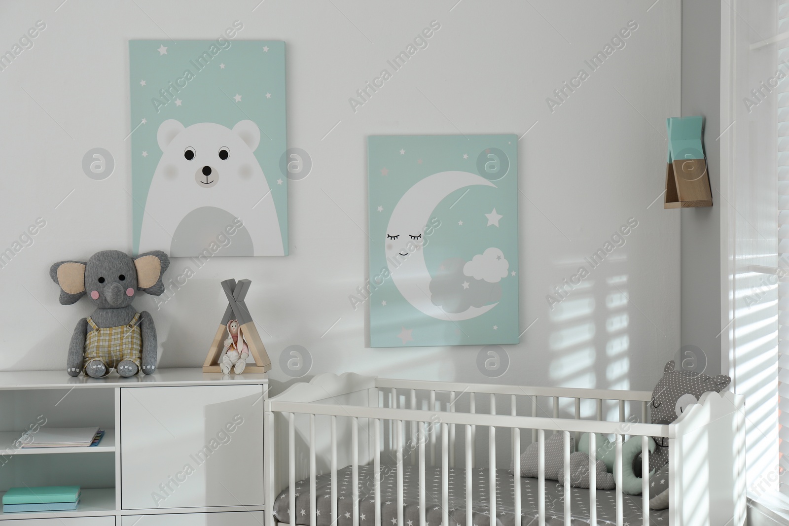 Photo of Stylish baby room interior with crib and cute wall art