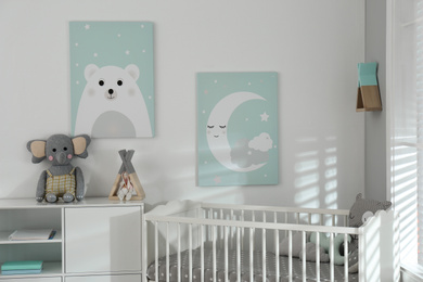 Stylish baby room interior with crib and cute wall art