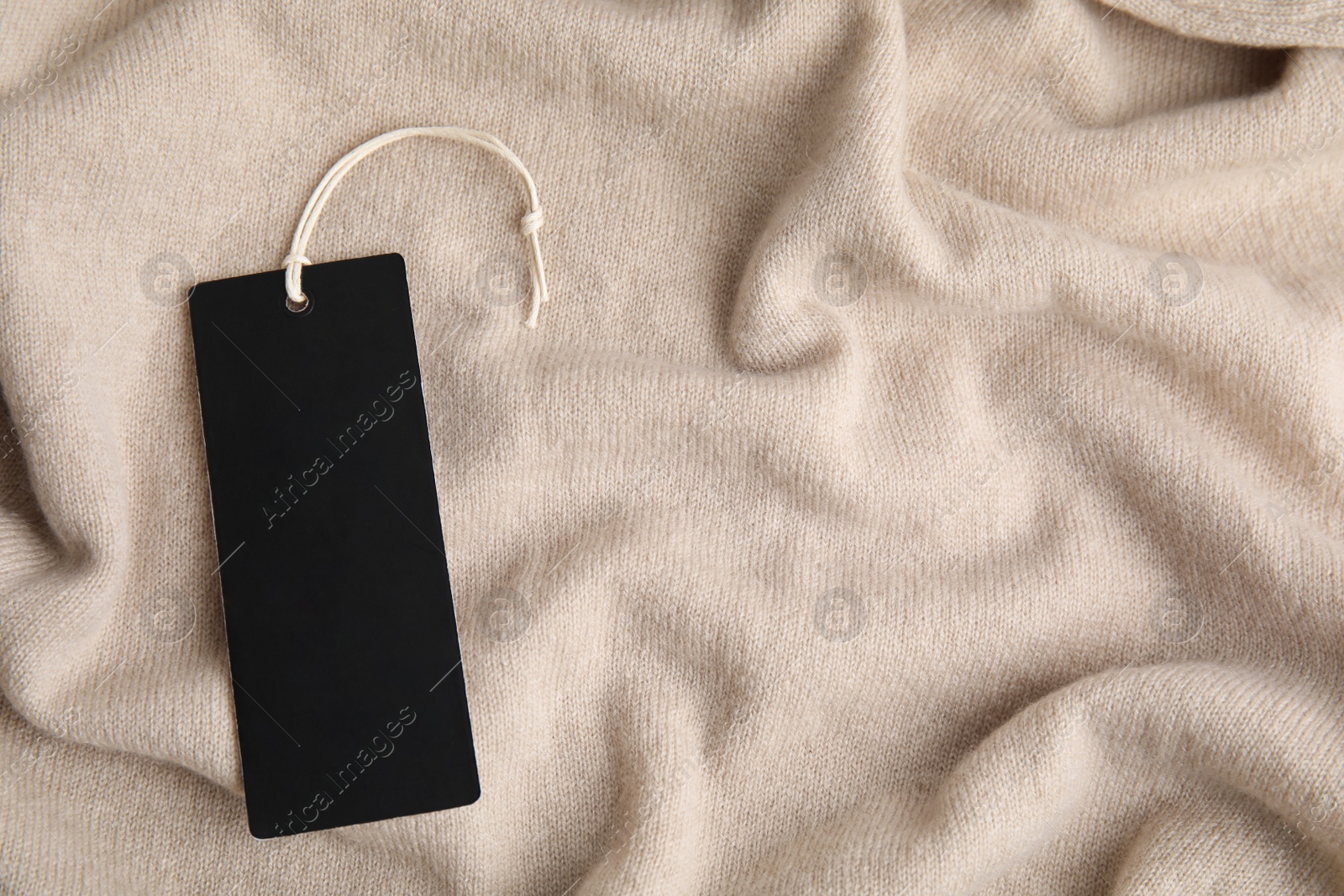 Photo of Warm beige cashmere sweater with tag, closeup