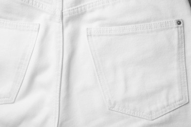 White jeans with pockets as background, top view