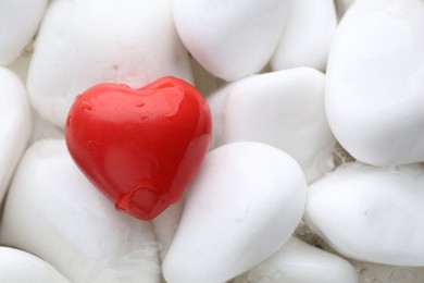 Photo of Red decorative heart on stones and water, top view. Space for text