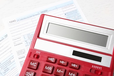 Photo of Calculator and document on white table, closeup. Tax accounting
