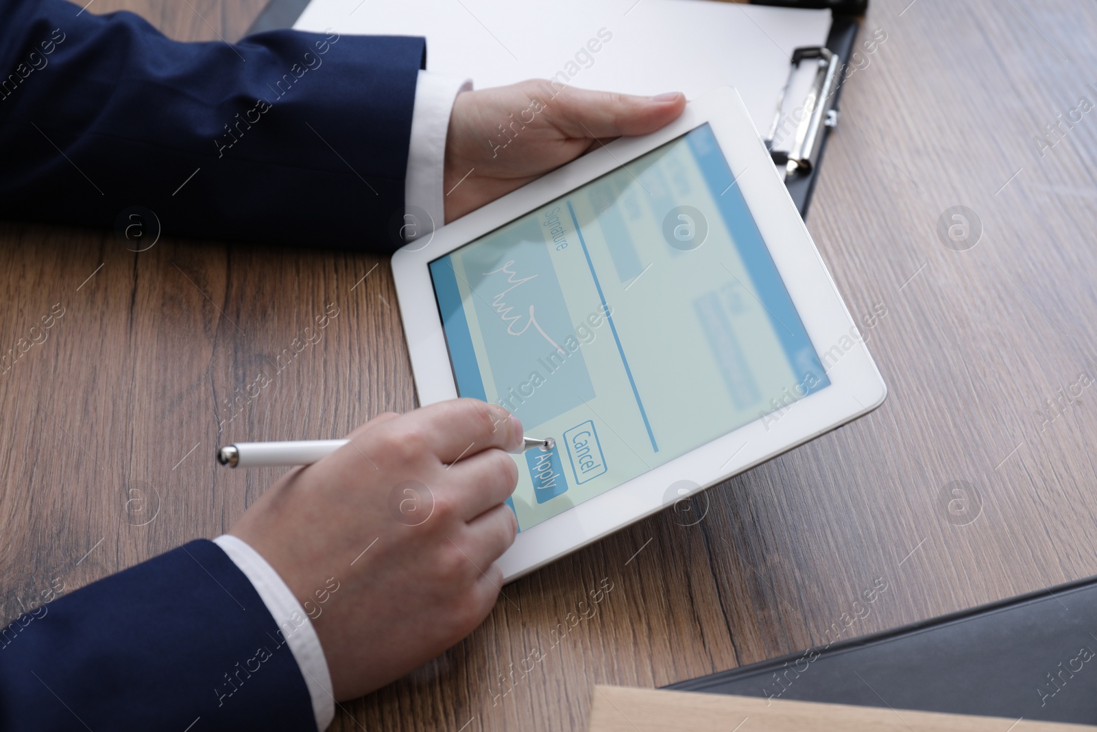 Image of Electronic signature. Man using stylus and tablet at wooden table, closeup