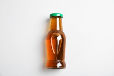 Photo of One bottle with tasty drink on color background, top view