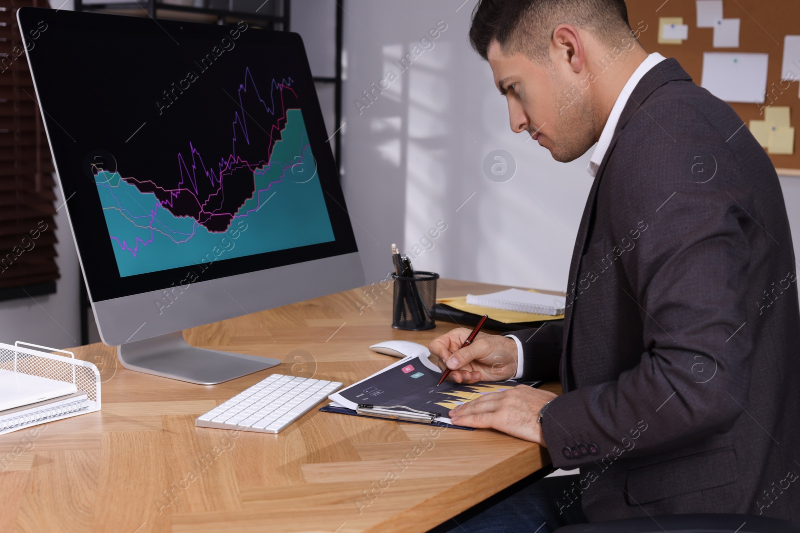 Photo of Businessman working with computer and graph in office. Forex trading