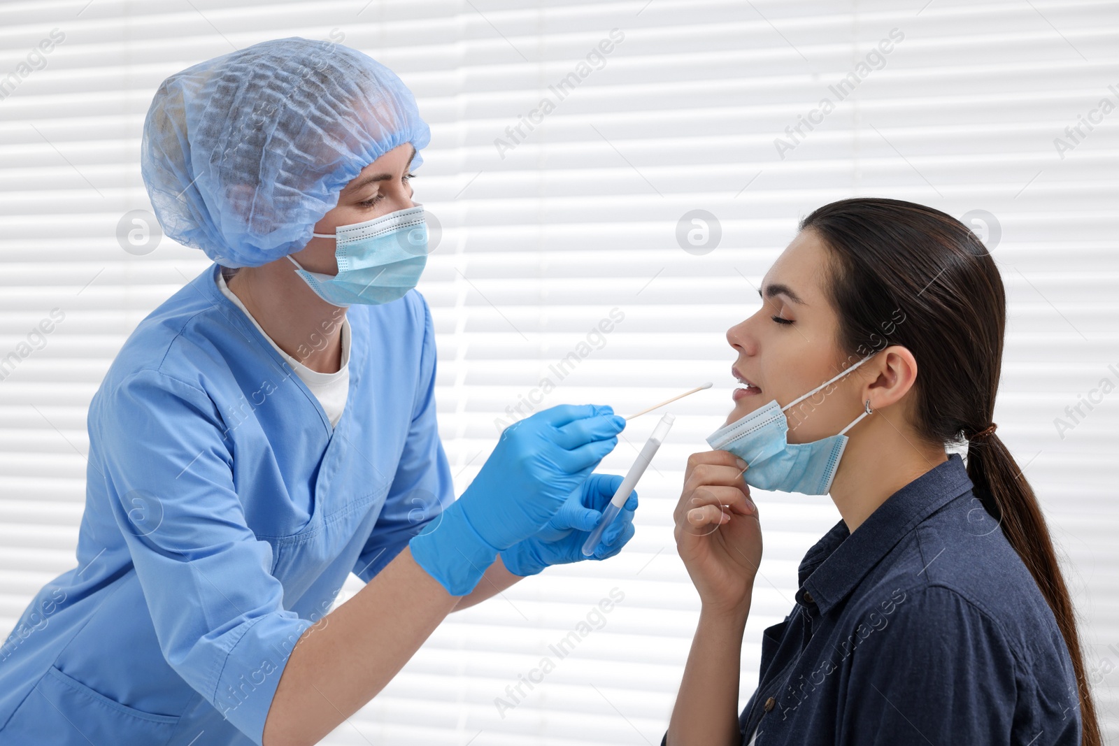 Photo of Laboratory testing. Doctor taking sample from patient's mouth with cotton swab in hospital