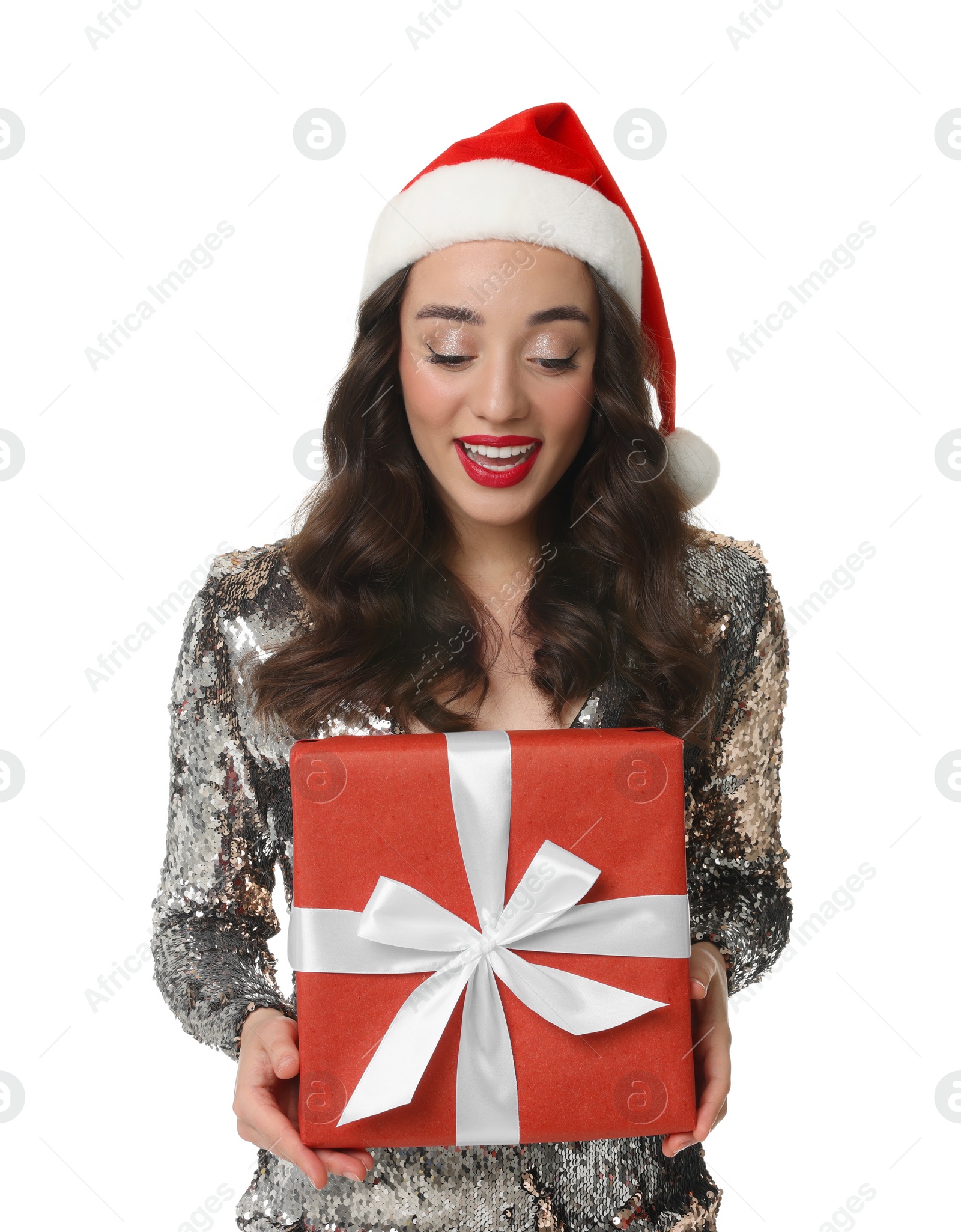 Photo of Beautiful young woman in stylish dress and Santa hat with Christmas celebration gift isolated on white