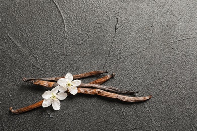 Vanilla sticks and flowers on grey background