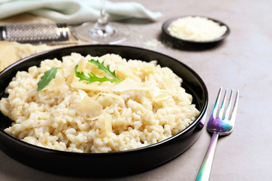 Photo of Delicious risotto with cheese on grey table, closeup