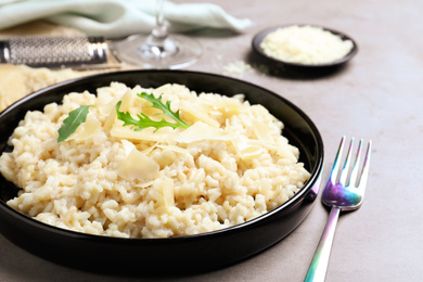 Delicious risotto with cheese on grey table, closeup