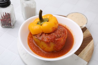 Photo of Delicious stuffed bell pepper served on white tiled table, closeup