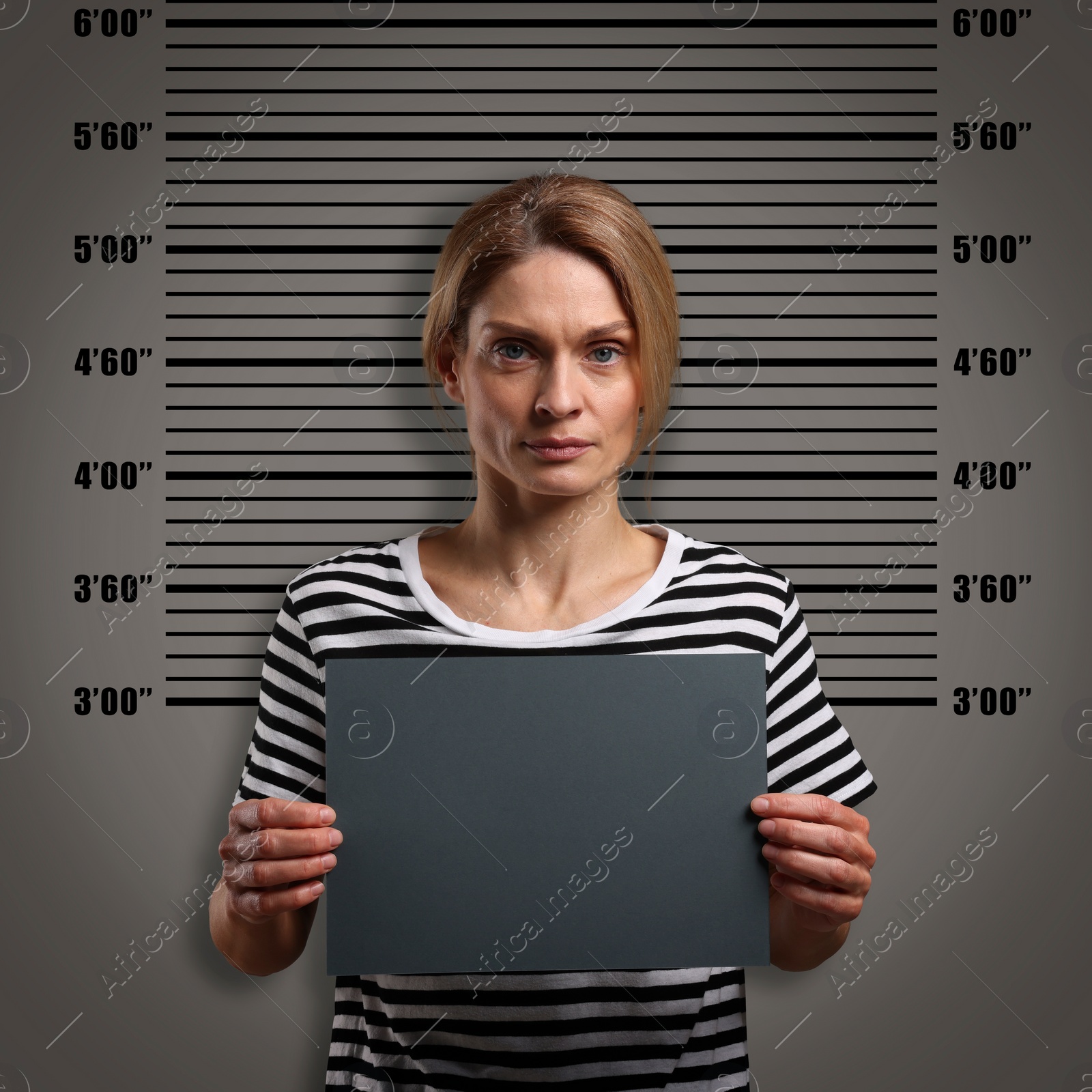 Image of Criminal mugshot. Arrested woman with blank card against height chart