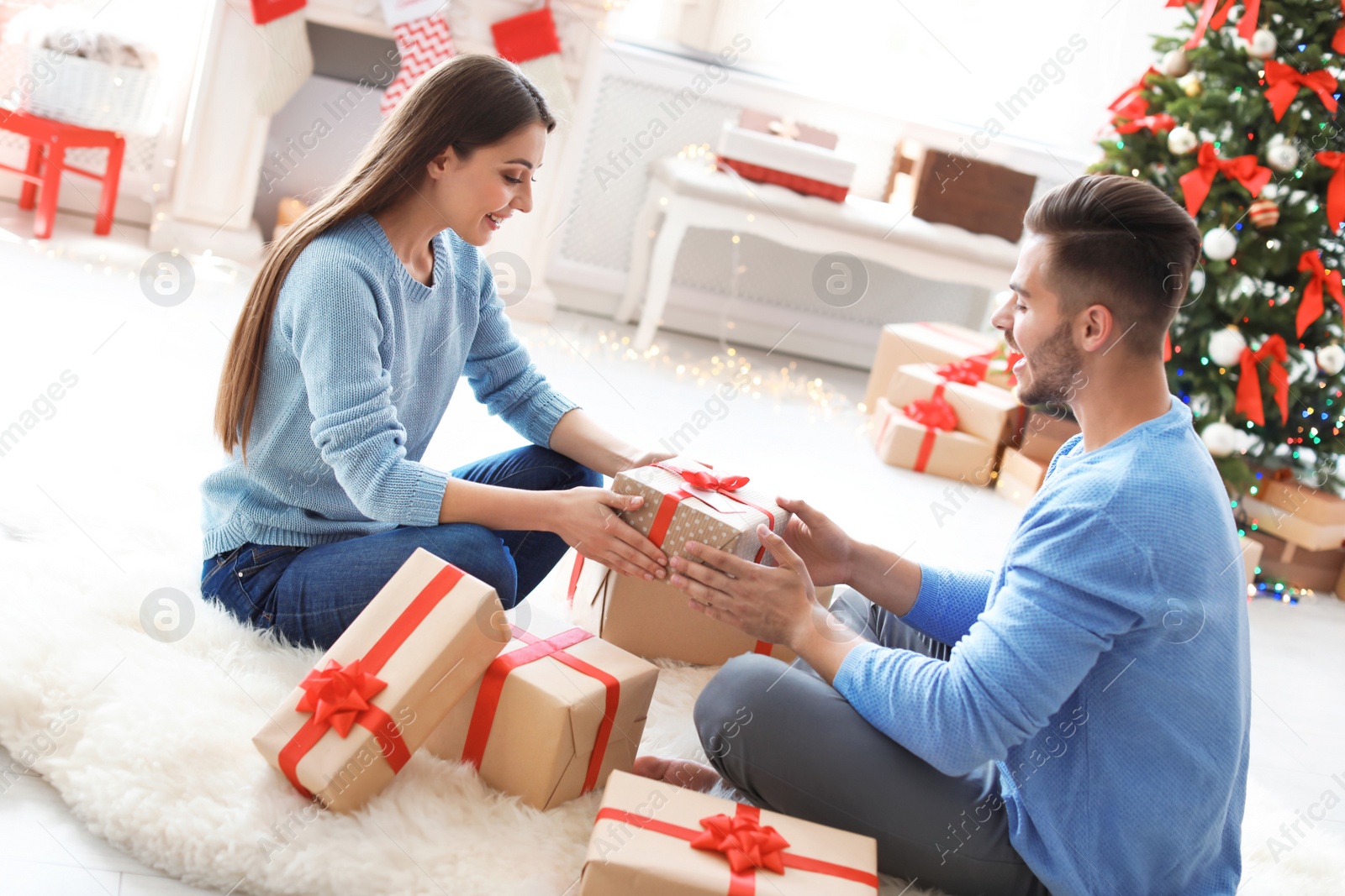 Photo of Young couple with Christmas gift at home