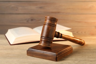 Photo of Wooden gavel and sound block on table, closeup