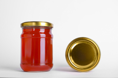 Photo of Glass jars of wildflower honey isolated on white