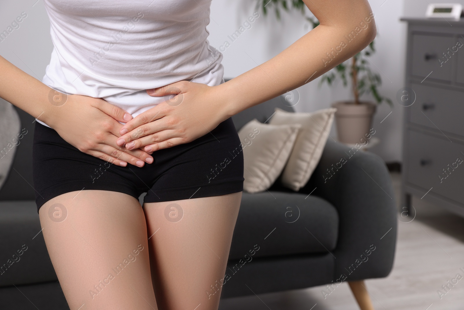 Photo of Woman suffering from cystitis at home, closeup. Space for text