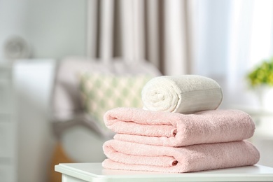 Photo of Clean soft terry towels on table indoors. Space for text