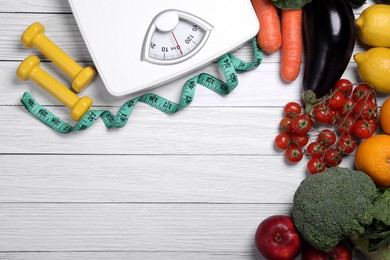 Photo of Scales, measuring tape, dumbbells, fresh fruits and vegetables on white wooden table, flat lay with space for text. Low glycemic index diet