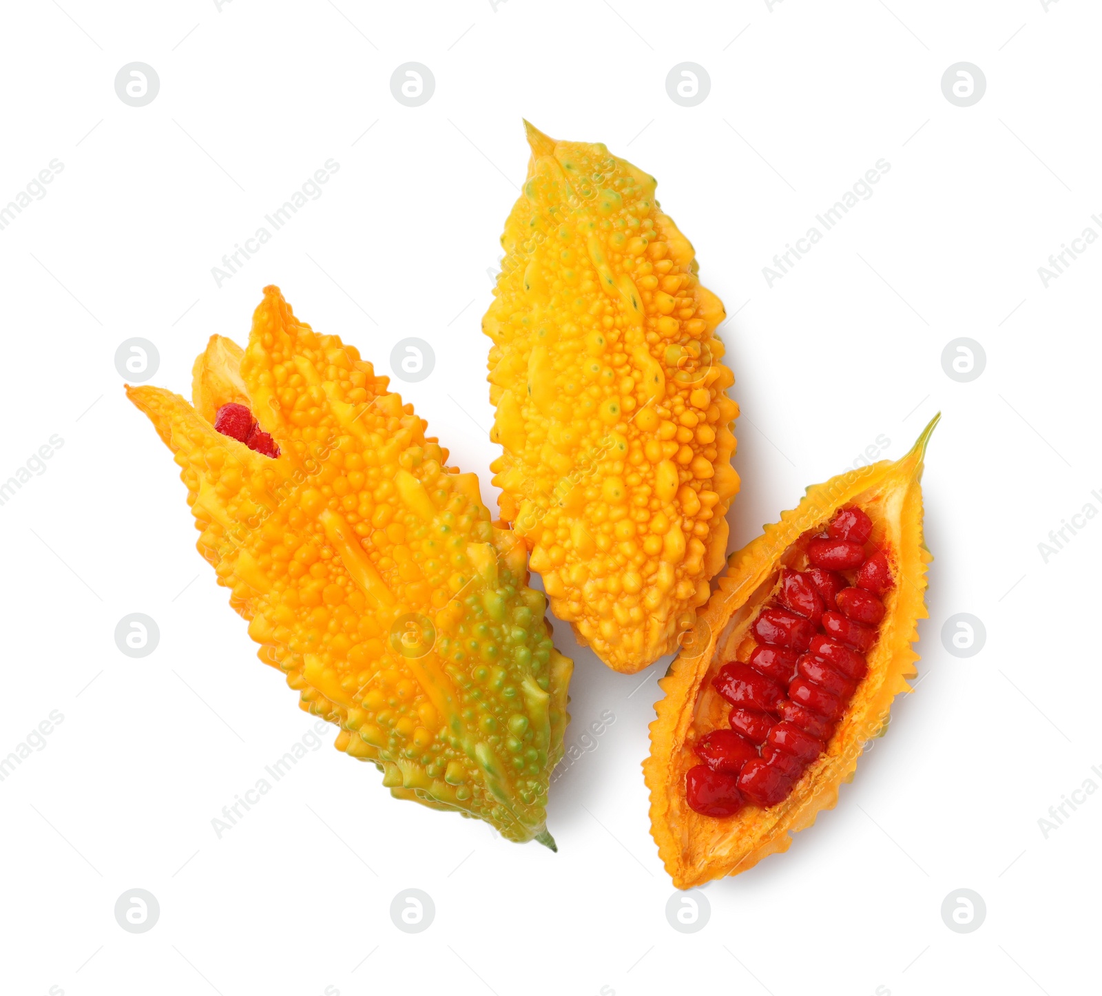 Photo of Whole and cut ripe bitter melons on white background, top view