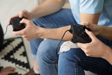 Young couple playing video games at home, closeup
