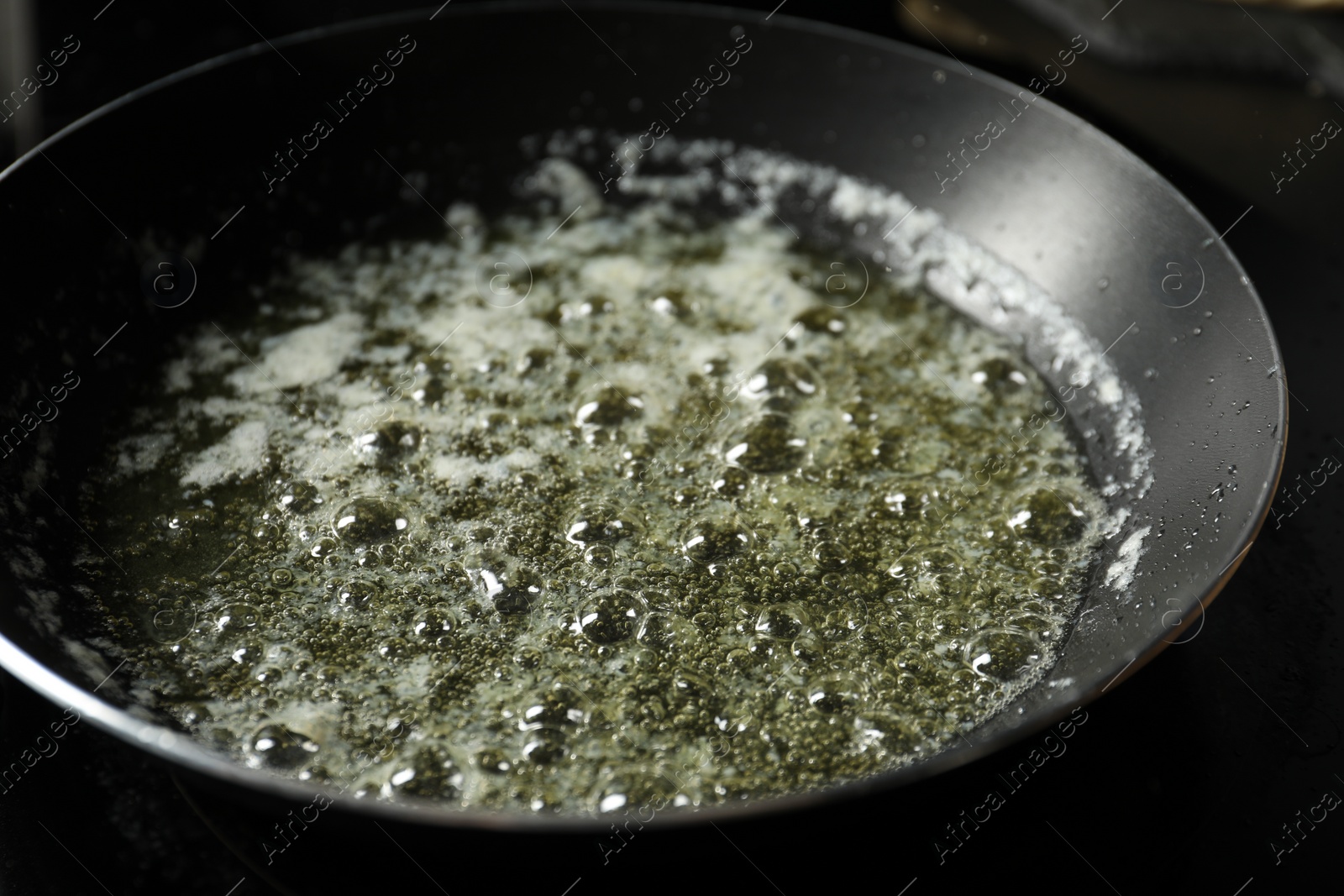 Photo of Melting butter in frying pan on table, closeup