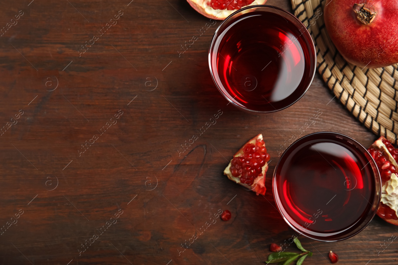 Photo of Pomegranate juice and fresh fruits on wooden table, flat lay. Space for text